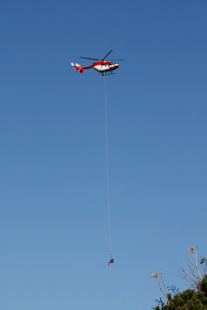 Rescue helicopter releasing a man on a rope - Photo, Image