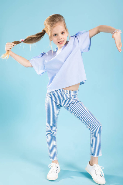 Full-length portrait of a beautiful girl in blue clothes on a blue background. - Photo, image