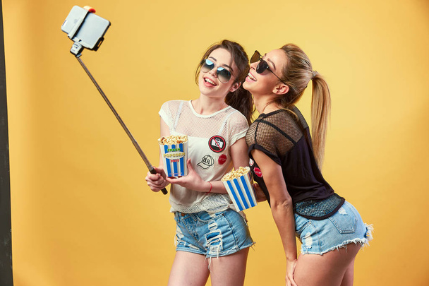 Women taking selfie with popcorn - Фото, изображение