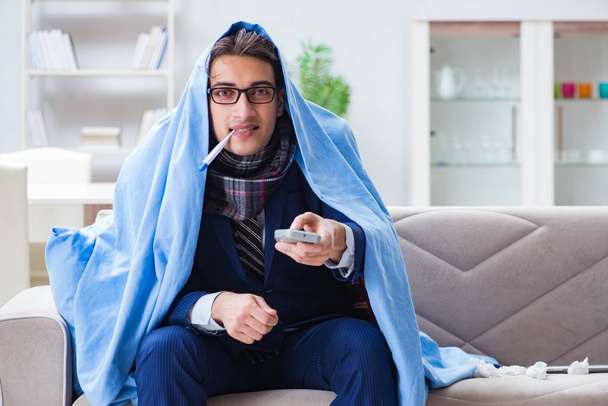 Angestellter Geschäftsmann schaut Fernsehen, während er an Grippe erkrankt ist - Foto, Bild