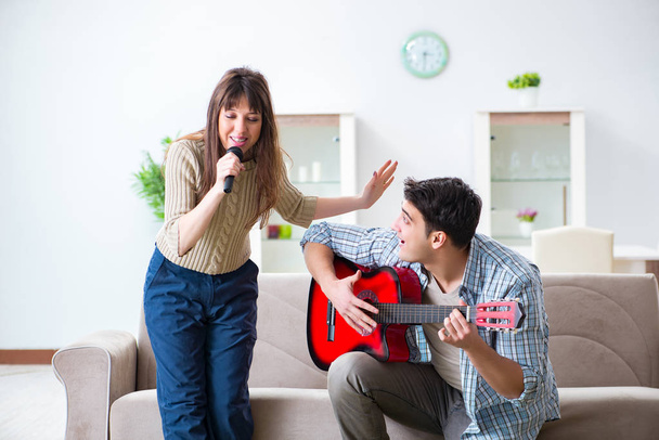 Família jovem cantando e tocando música em casa - Foto, Imagem