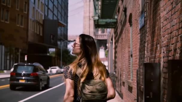 Camera follows Caucasian female tourist in fashionable sunglasses exploring old streets of New York City, slow motion. - Felvétel, videó