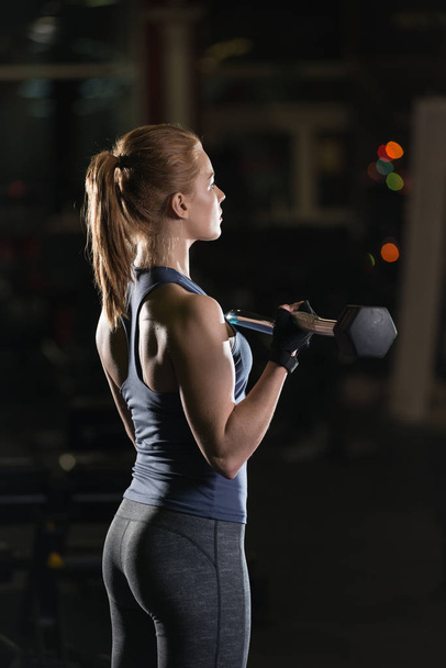 Young woman lifting the dumbbells - 写真・画像