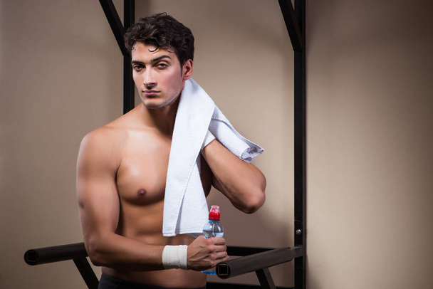 Thirsty man drinking water in sports gym - Valokuva, kuva