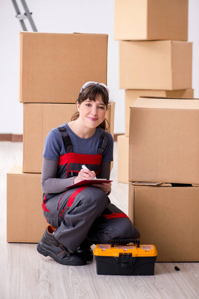 Woman contractor moving boxes in relocation concept - Foto, imagen