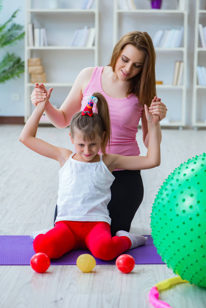 Κορίτσι και μητέρα άσκηση στο σπίτι - Φωτογραφία, εικόνα