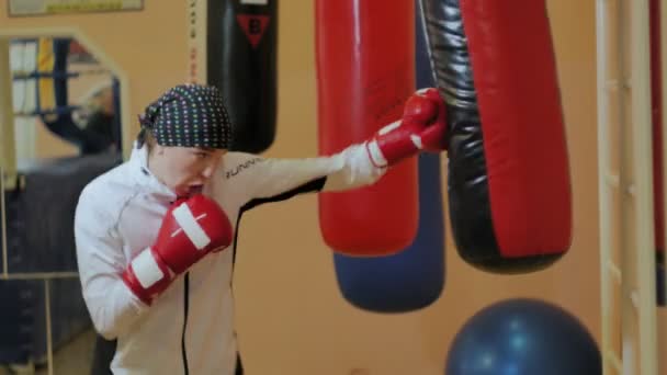 Boxerin trainiert Boxsack im Fitnessstudio heftige Kraftsport-Body-Kickboxer-Serie - Filmmaterial, Video