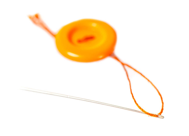 iş parçacığı ve iğne beyaz izole arka planda turuncu düğmesine - Fotoğraf, Görsel