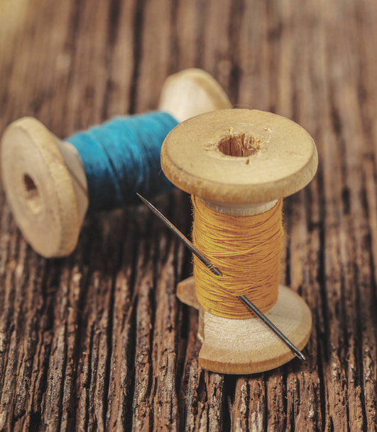 colored threads and needle on wooden background - Φωτογραφία, εικόνα