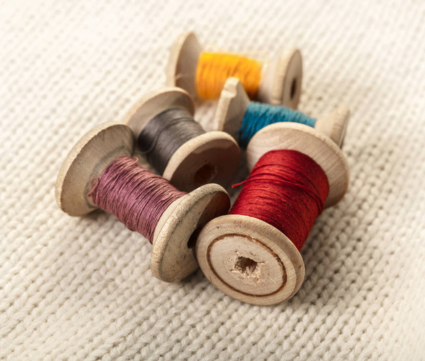 coils of colored thread on white knitted fabric - Photo, Image