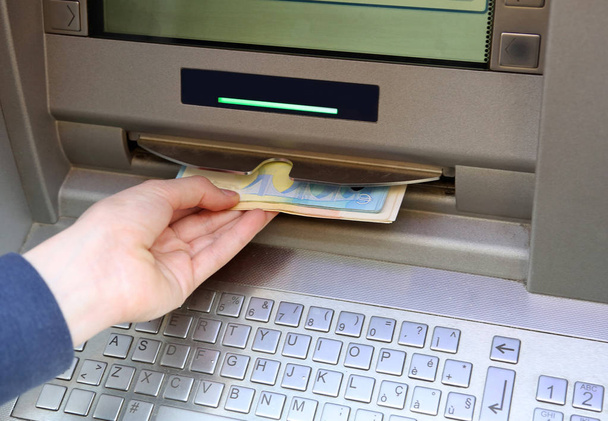 μηχάνημα ΑΤΜ με πολλά χρήματα ευρώ και το χέρι - Φωτογραφία, εικόνα