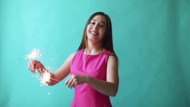 Close-up of a beautiful woman holding with sparkler. Focus on foreground, on sparkler. - Кадри, відео