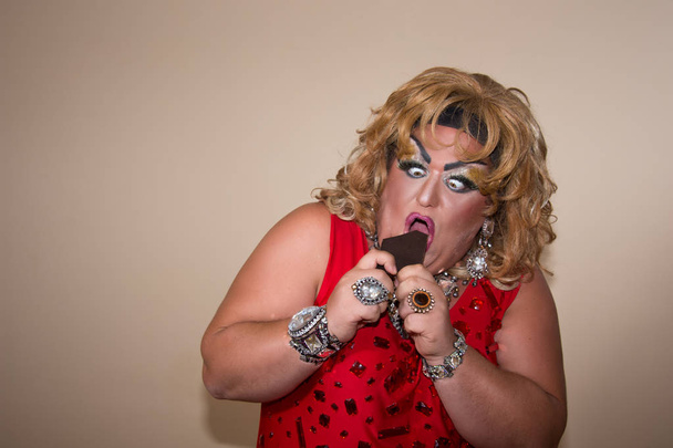 Funny travesty actor. Drag queen and chocolate. Fat man and make-up. - Photo, Image