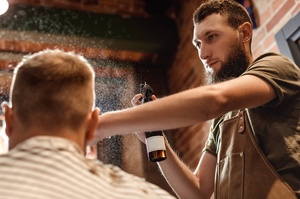 Barber and bearded man in barber shop - Фото, изображение