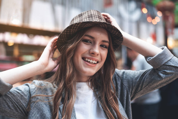 Pretty young woman is smiling outdoors - Фото, изображение