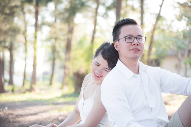 Asian para, mężczyzna i kobieta razem siedzi w parku - Zdjęcie, obraz
