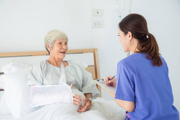 Senior asiatico femmina paziente sorridente con infermiera che venire a visitare
 - Foto, immagini