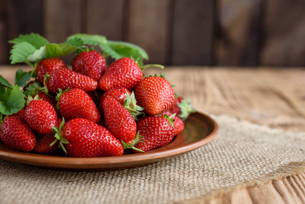 Leckere Erdbeeren auf einem Holztisch. Es kann als Hintergrund verwendet werden - Foto, Bild