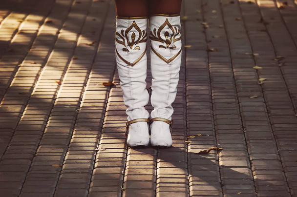 Bílé Dámské boty jsou na chodníku. Dívka v Dámské kovbojské boty stojí sám a čeká - Fotografie, Obrázek