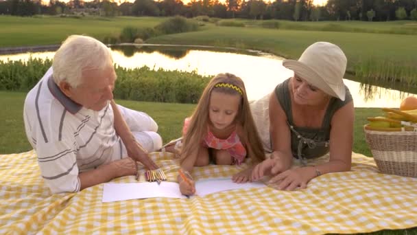 Großeltern helfen Enkelin beim Zeichnen. - Filmmaterial, Video