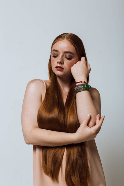 Portrait of a beautiful girl with long hair, makeup and freckles - Φωτογραφία, εικόνα