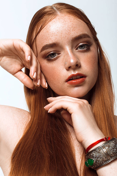 Porträt eines schönen Mädchens mit langen Haaren, Make-up und Sommersprossen - Foto, Bild