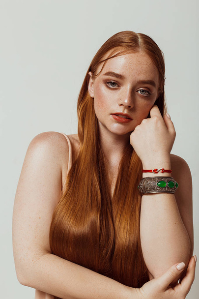 Portrait of a beautiful girl with long hair, makeup and freckles - Φωτογραφία, εικόνα