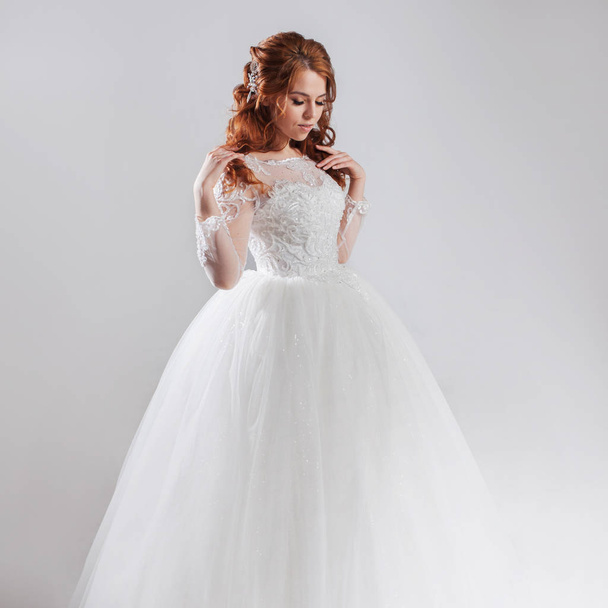 Lovely young woman bride in lavish wedding dress. Light background. - Фото, зображення