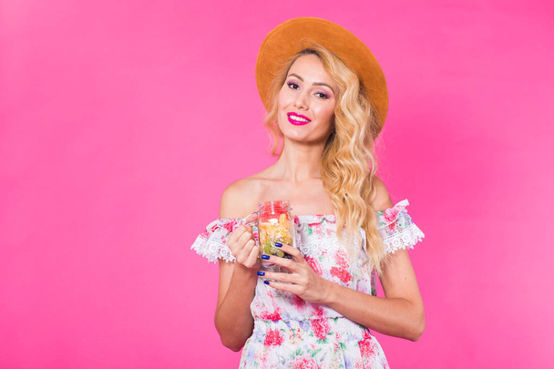 Young beautiful woman with fruit jar on pink background with copyspace - Fotografie, Obrázek
