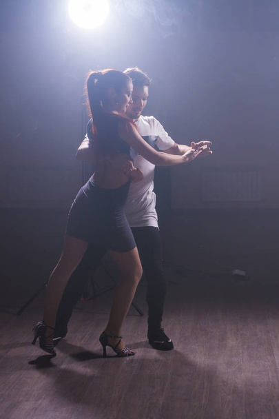 Молода пара танцює латинський танець Бачата, Меренг, Сальса. Дві елегантні пози в танцювальному класі
 - Фото, зображення