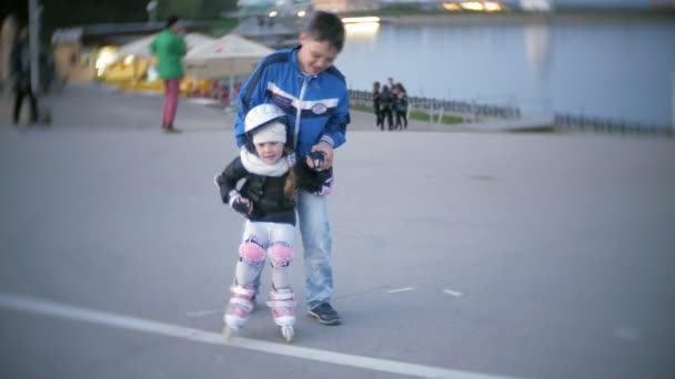 little girl dresses learn to skate. Concept: sport, lifestyle, health. - Footage, Video