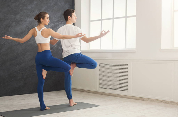 Paar trainiert Yoga in Baumpose. - Foto, Bild