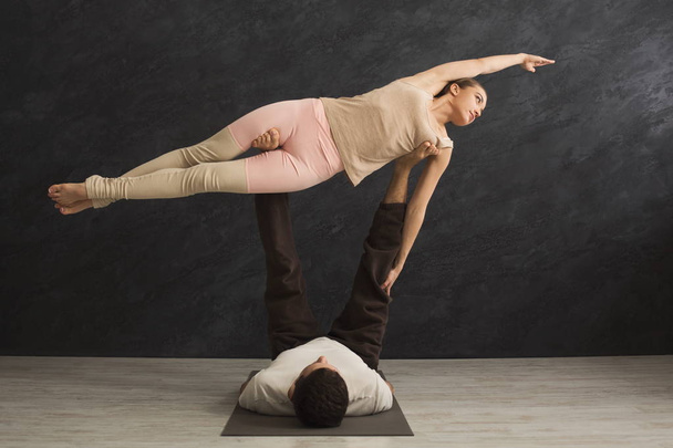 Nuori pari harjoitellaan acrojooga matto yhdessä
 - Valokuva, kuva