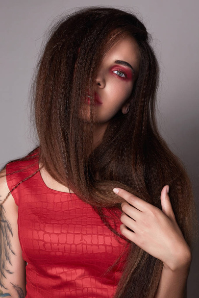 young woman make-up.beautiful girl with red eyeshadows make-up.tattoo - 写真・画像