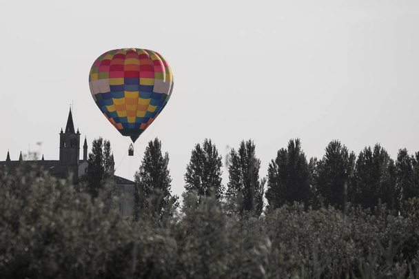イタリア教会の塔近くの空にカラフルな熱気球. - 写真・画像