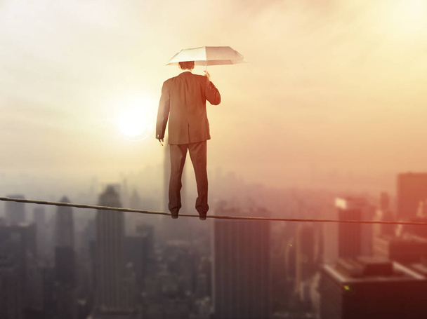 Equilíbrio da vida profissional conceito de emprego: homem de negócios equilibrando na corda alta acima da cidade
 - Foto, Imagem