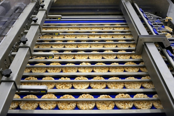 kerek diétás kenyerek válogatása a szállítószalagon automatizált gépen - Fotó, kép