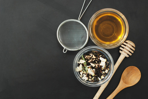 Herbal tea Healthy Drink in bowl and sieve over Black Background copy space. Healthy Drink, - 写真・画像