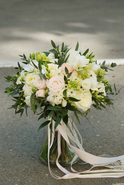 White Wedding Bouquet Roses Pink flowers and Ruscus Leaves with Robbons on Gray Asphalt Background. - Fotografie, Obrázek