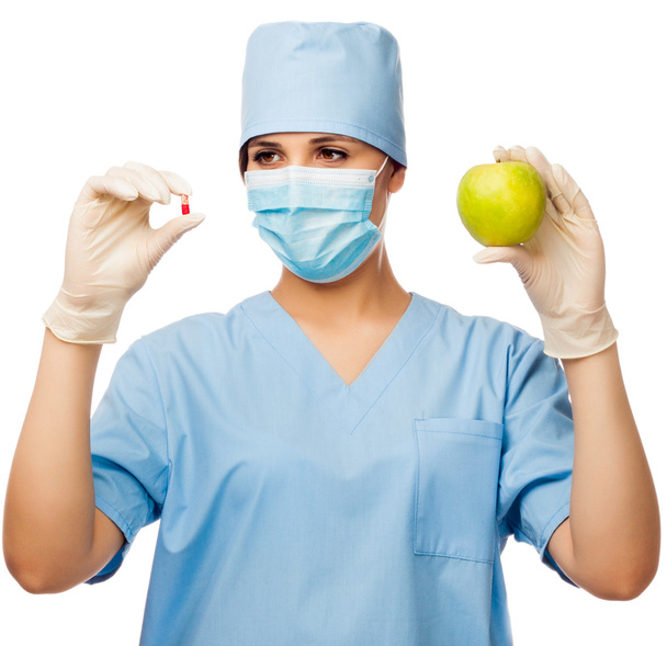 Young doctor holding pill and apple - Foto, Imagem