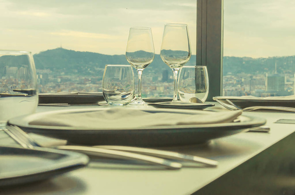 glasses and cutlery on the restaurant table with a view of the city of Barcelona - Фото, изображение