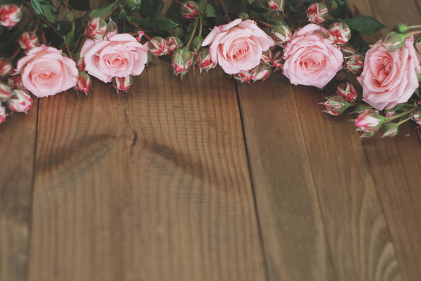 Roze rozen boeket over houten tafel. Bovenaanzicht met kopie ruimte. Afgezwakt - Foto, afbeelding