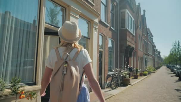 A woman in a hat is enjoying a stroll through the streets of Delft in the Netherlands. Holiday in Europe concept - Footage, Video