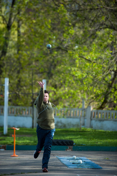 МОСКВА, РОССИЯ - 13 мая 2017 года: Российский спортсмен Андрей Домарев бросает металлический мяч в бочче воло на турнире Day Running
. - Фото, изображение
