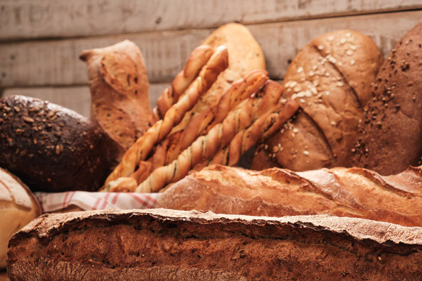 Friss illatos kenyér az asztalon. Élelmiszer-fogalom Búzasütemény fadobozban - Fotó, kép