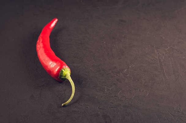 red pepper on a dark stone background/red hot pepper on a dark stone background. selective focus. Copy spac - Photo, image