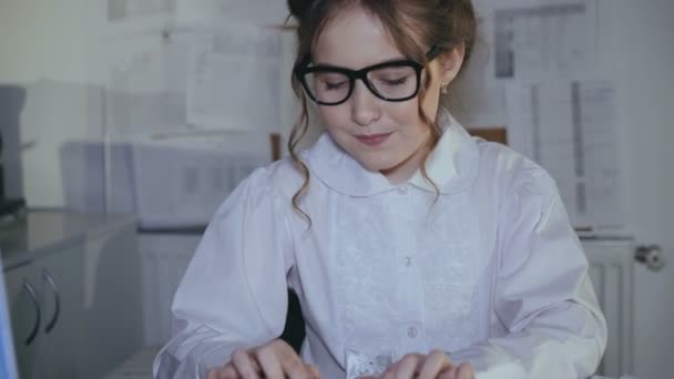 Usmívající se dívka obsazeno psaní na klávesnici a používání diagramů - Záběry, video