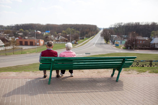 Yaşlı insanlar bir bankta oturup mesafe içine bakmak - Fotoğraf, Görsel