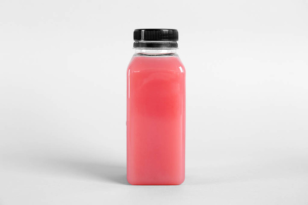 Bottle with delicious fresh juice on light background - Fotoğraf, Görsel