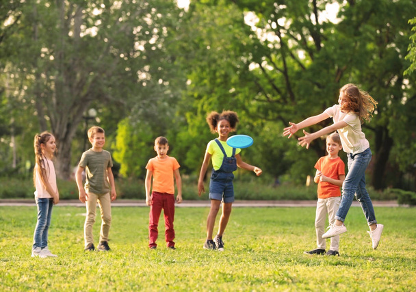 Cute little children playing with frisbee outdoors on sunny day - Foto, Imagem